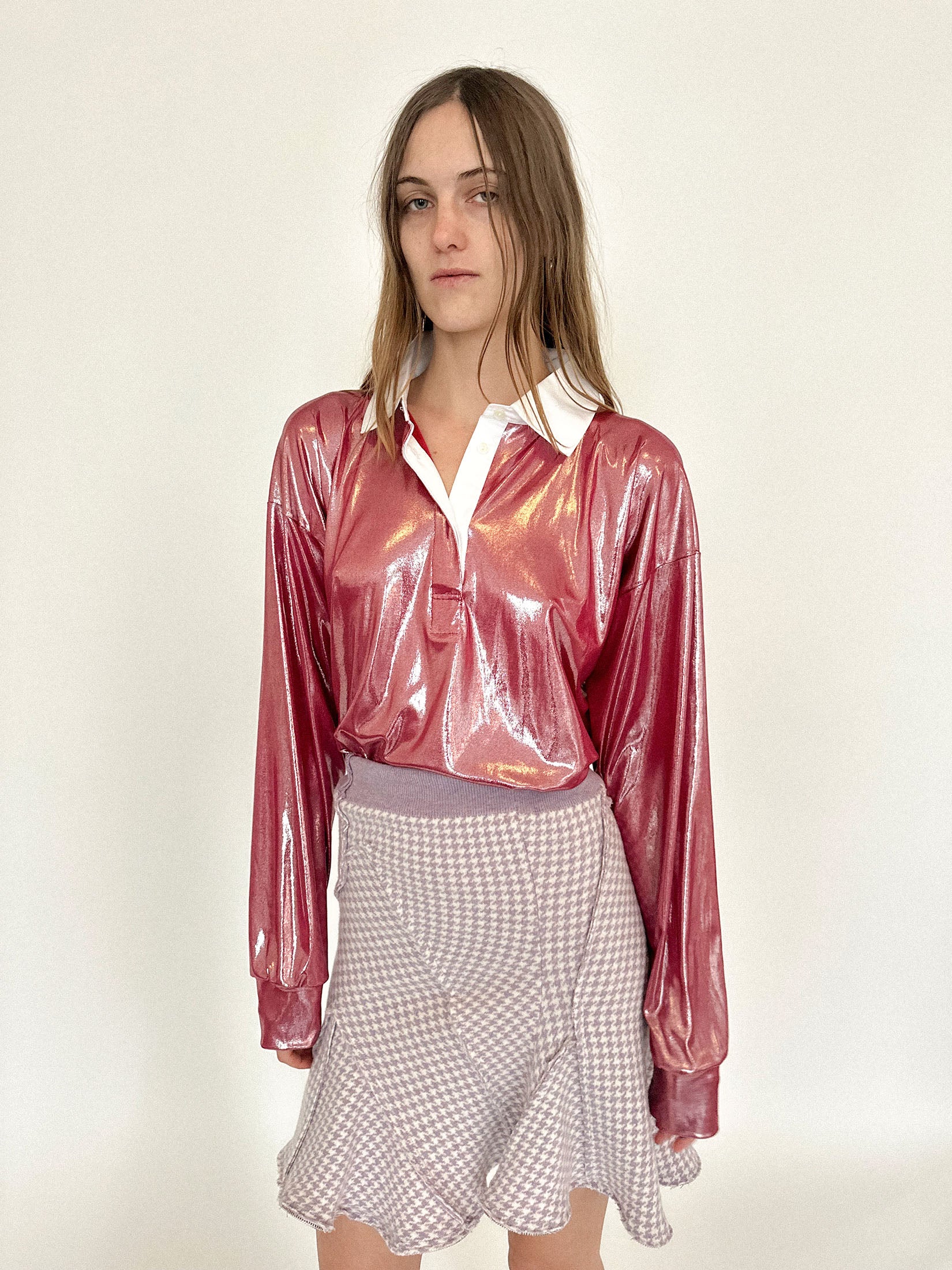 A rugby shirt by Talia Byre, cut loose in red jersey that gleams like a provocation under dim light.