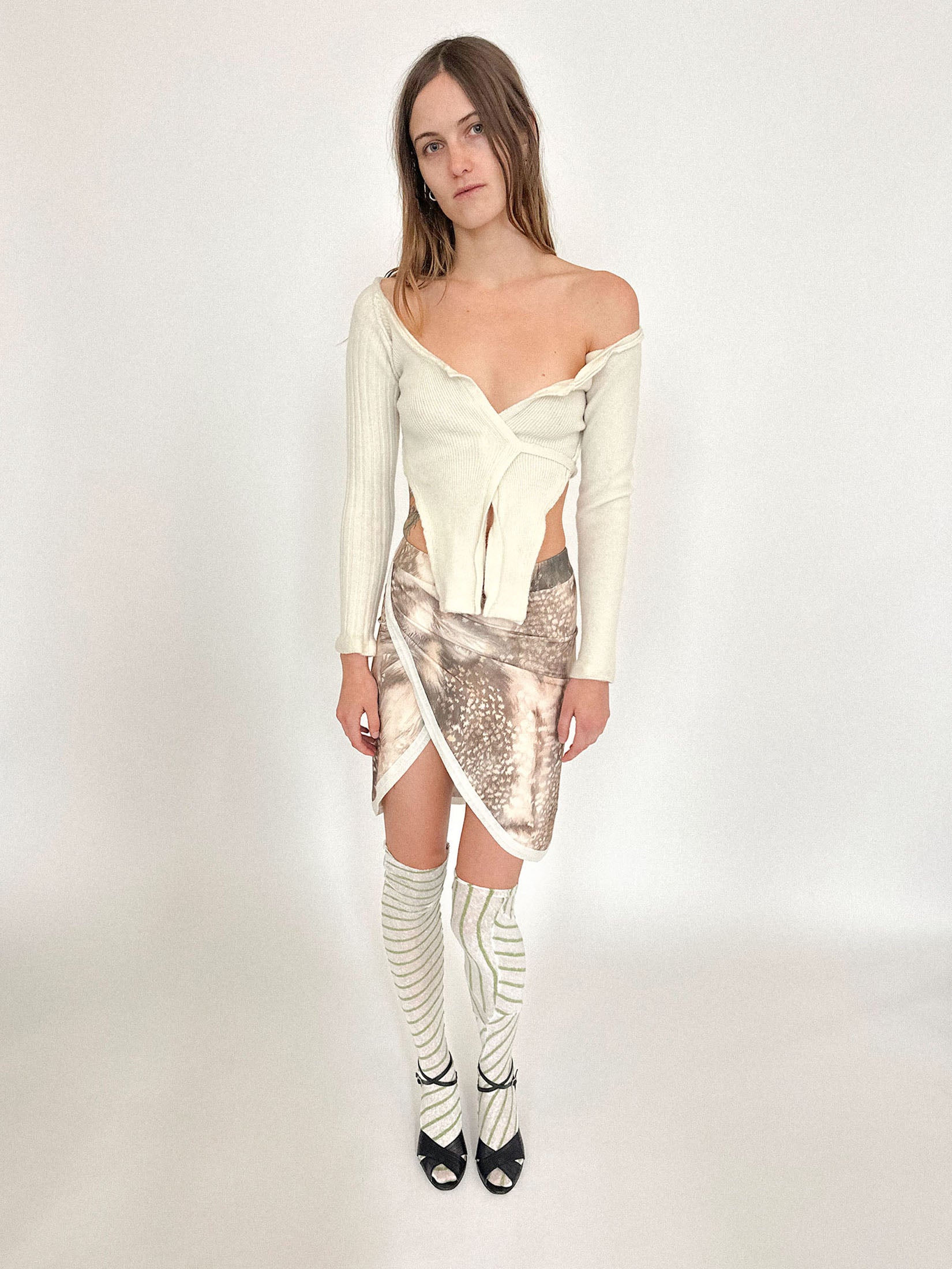 A V-neckline opens the frame just enough, balanced by a tie at the back that feels more like punctuation than closure.