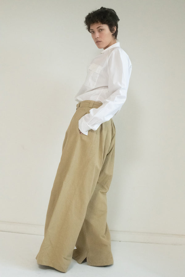 In the flickering shadows of the city, you glide through the night with a sense of purpose. The Margiela Pleated Pants are your signature—khaki, but not ordinary. 