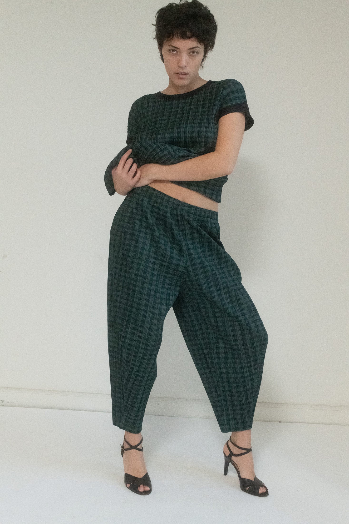 These cropped pants are poetry in motion, their iconic pleating creating an endless rhythm of texture and form. 