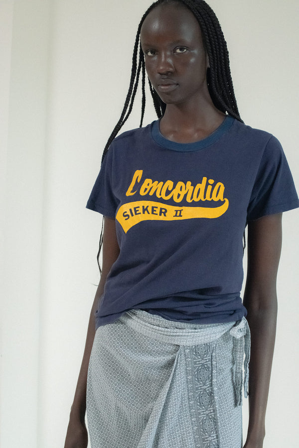 There’s something about this Vintage Concordia Tee—something that draws you in like the flicker of a neon sign at midnight.