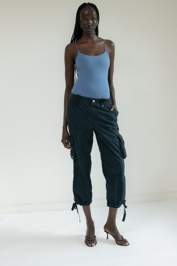 A whisper in navy moves through the haze—light on its feet, bold in its silence. The night hums with promise, and the drawstring cargo pant answers in soft steps and shadowed curves.