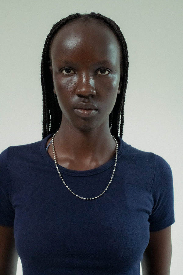 The Ball Chain Necklace by Laura Lombardi is all pulse and tension—linked spheres that trace the collarbone like a secret. 