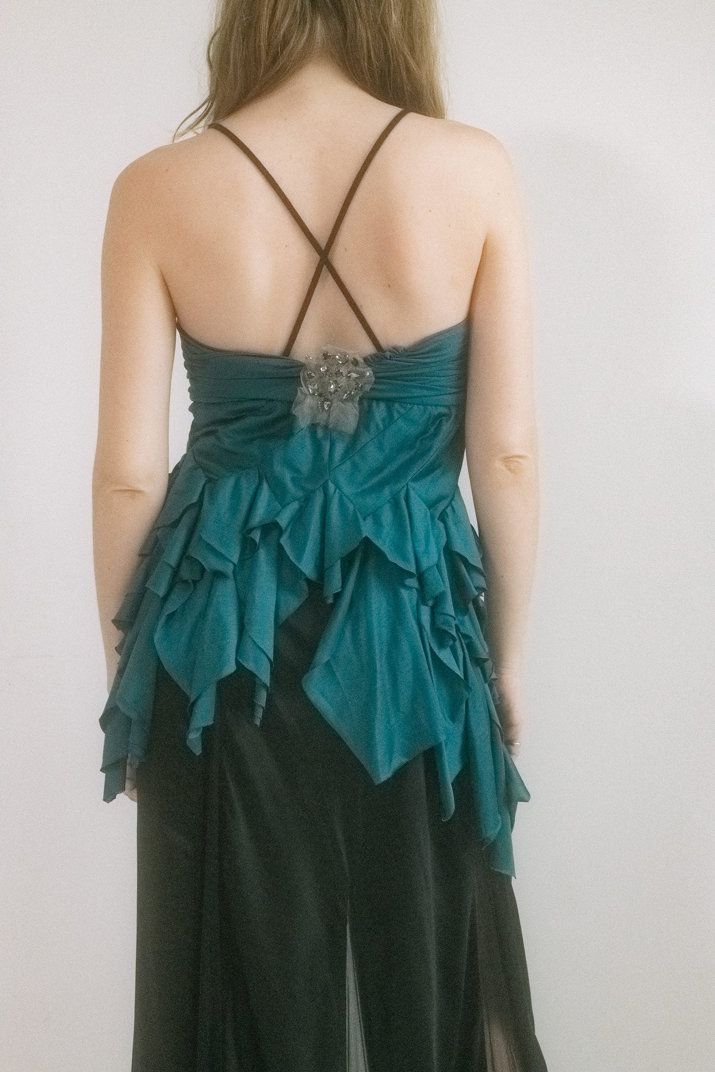 Ruffles and ruching cascade like whispered secrets, while an asymmetrical hem teases with unexpected angles. 
