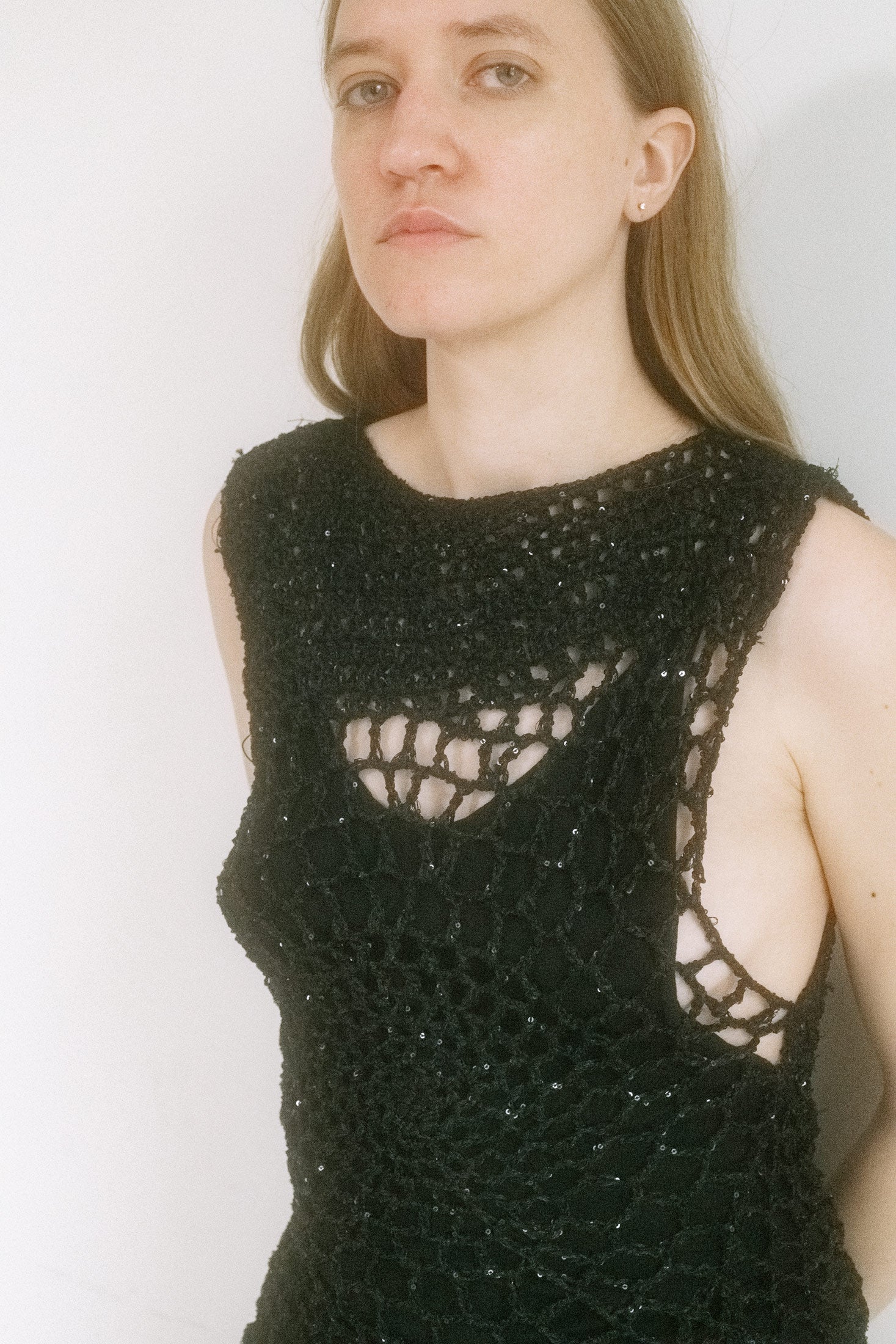 Sleeveless and sheer, it clings just enough to trace the body’s architecture while leaving the rest to fantasy. 
