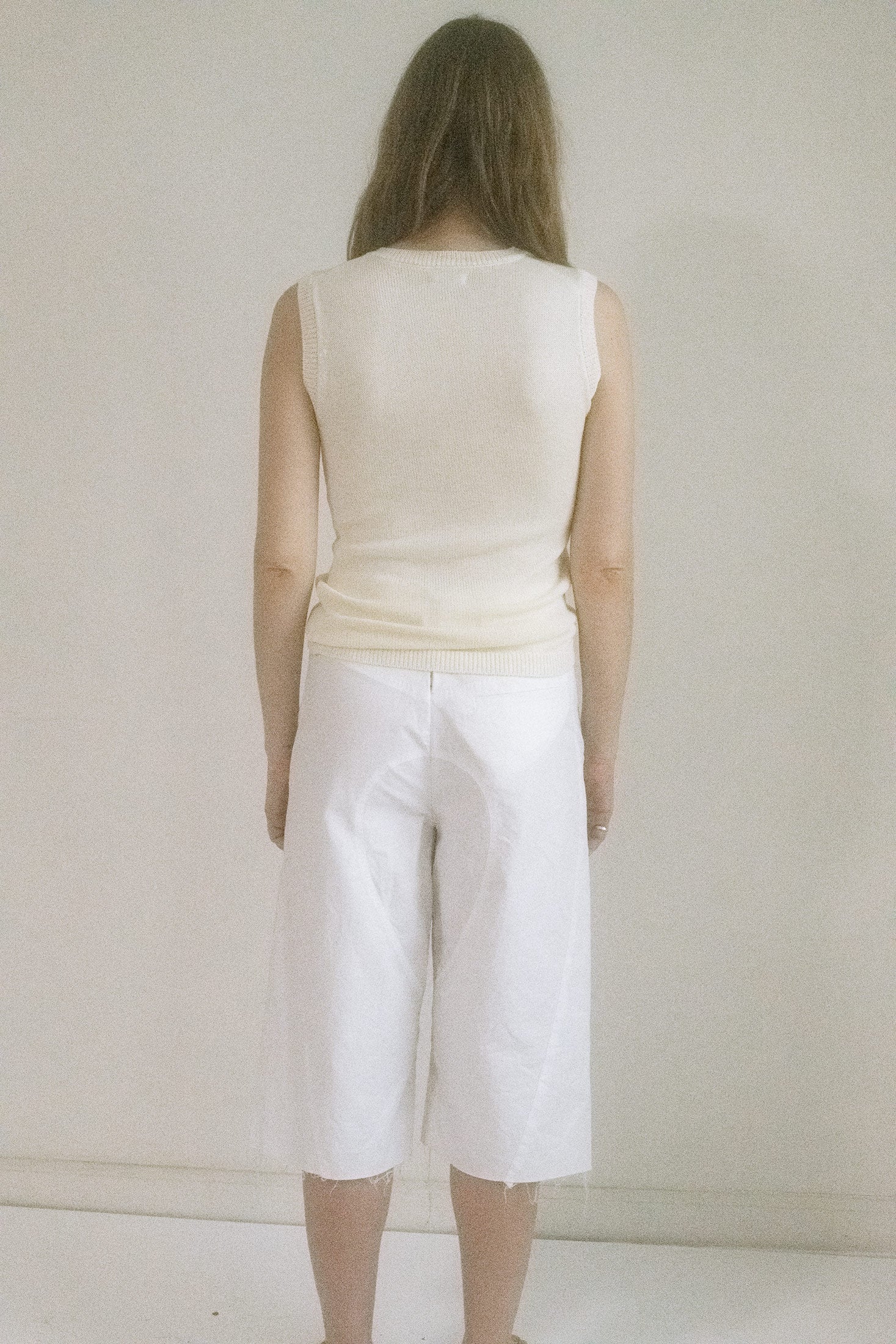 The sleeveless cut teases just enough, framing the neckline like a silent invitation—effortless sophistication wrapped in a breath of air.