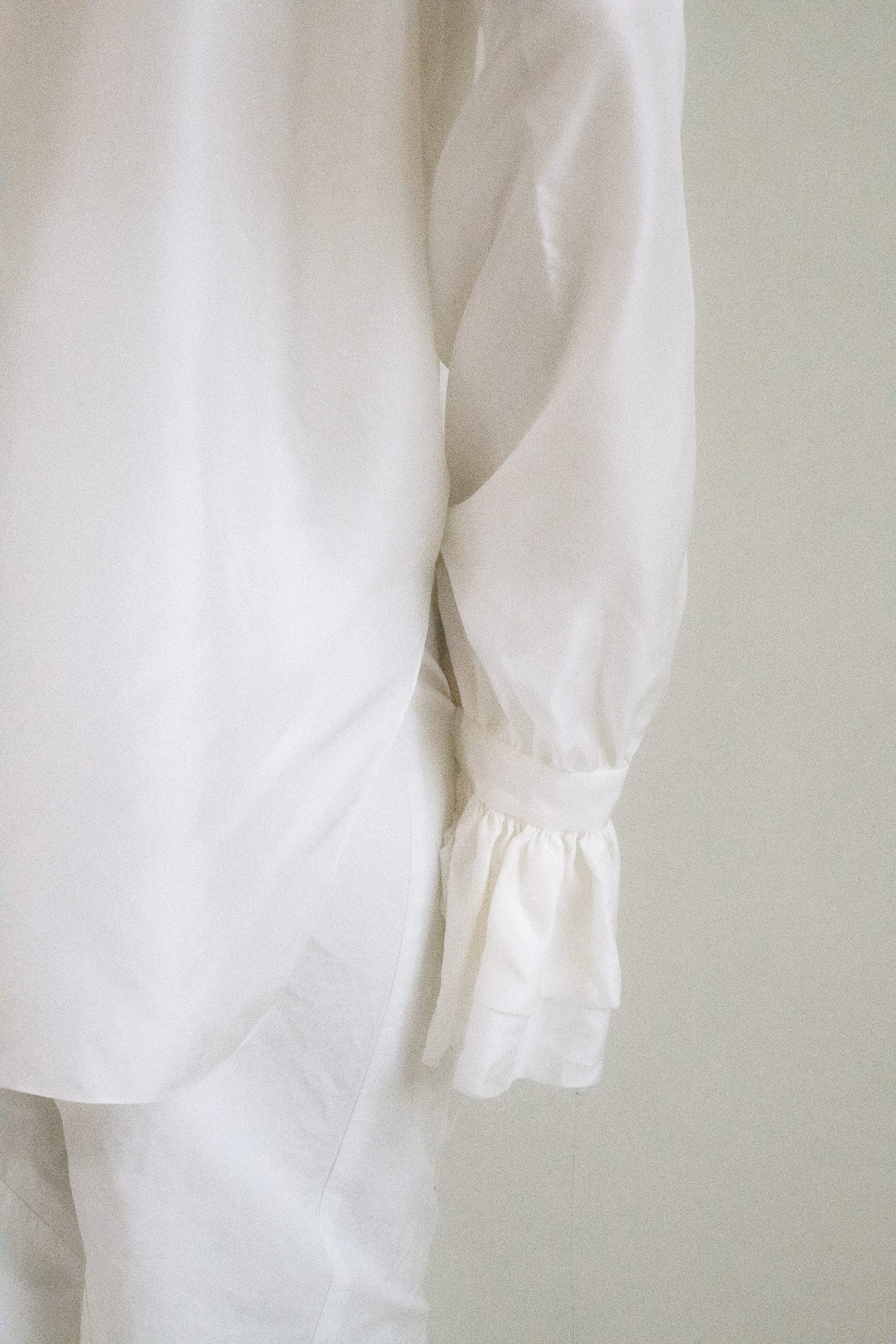 Billowy sleeves end in fluted wrists, a final, flirtatious flourish.
