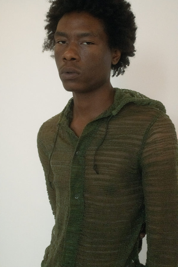 A vintage hooded top in moss green, textured and semi sheer against the skin.
