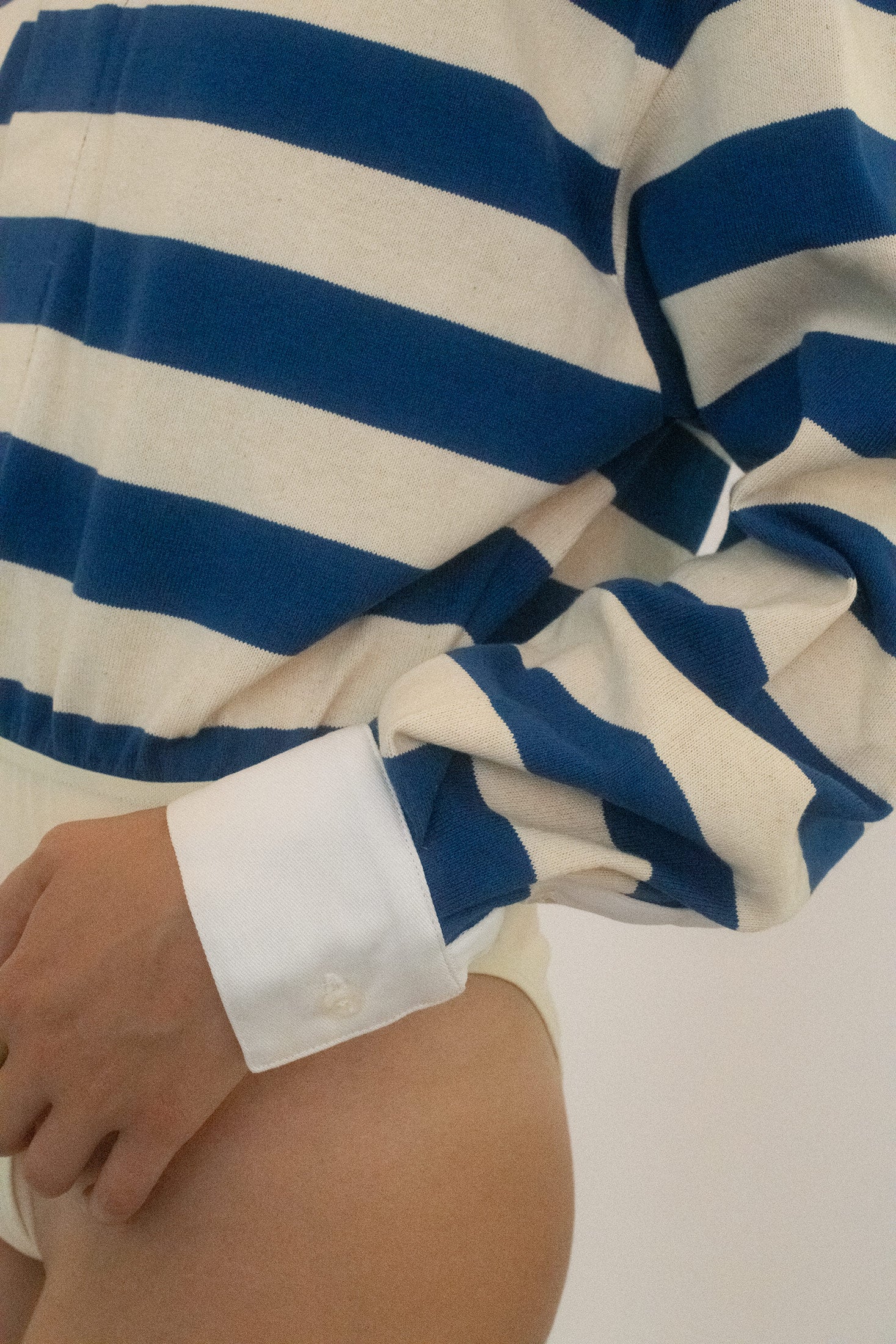 Contrasting white cuffs and collar frame the bodysuit with just enough structure to make the rest feel dangerous.