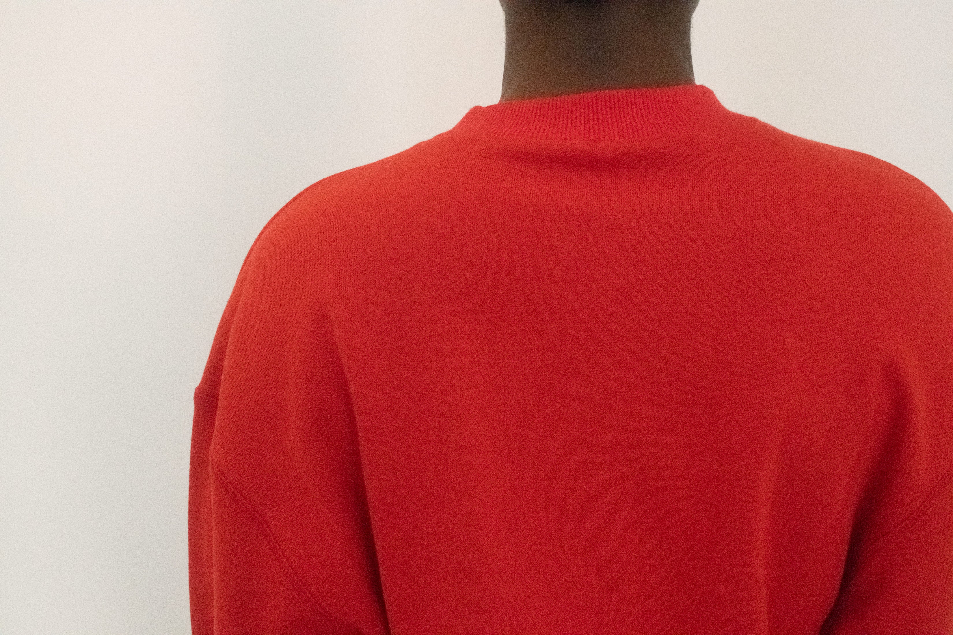 The crewneck frames the collarbone in quiet simplicity, while the fit drapes loose before cinching neatly at the waist, a casual gesture that still reads like control.