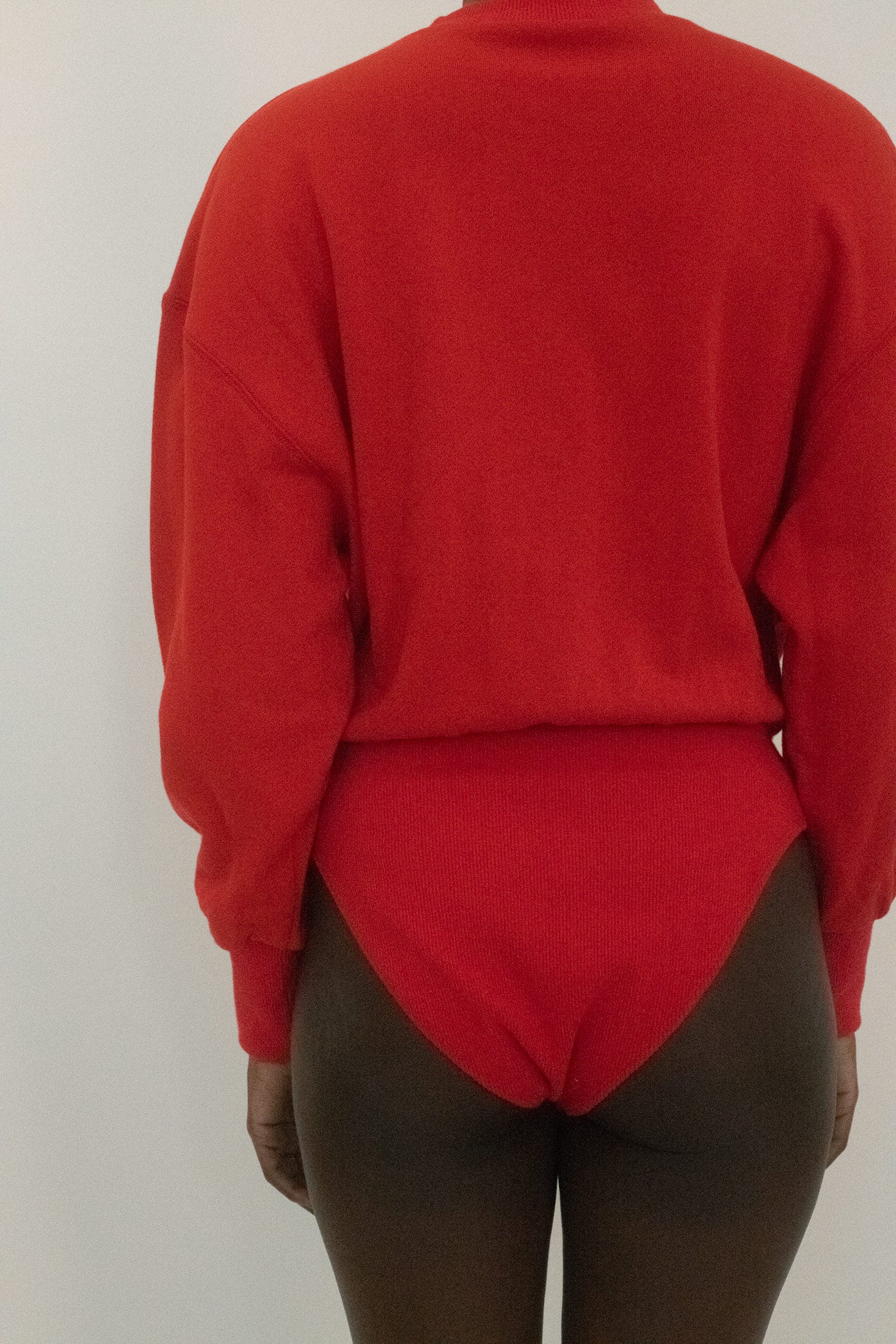 Cut from fine vibrant red sweatshirt material, it carries the ease of loungewear but the precision of something meant to be seen.