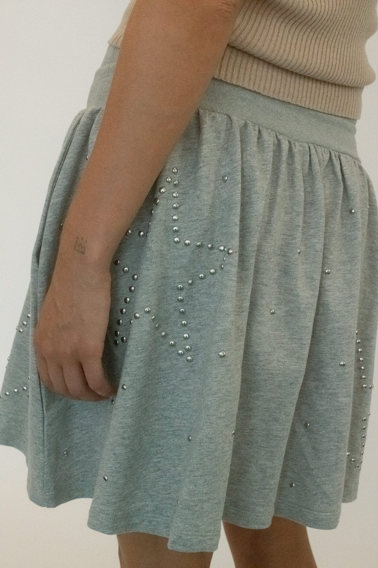 Silver studs scatter across the surface: glinting, catching, never quiet. 