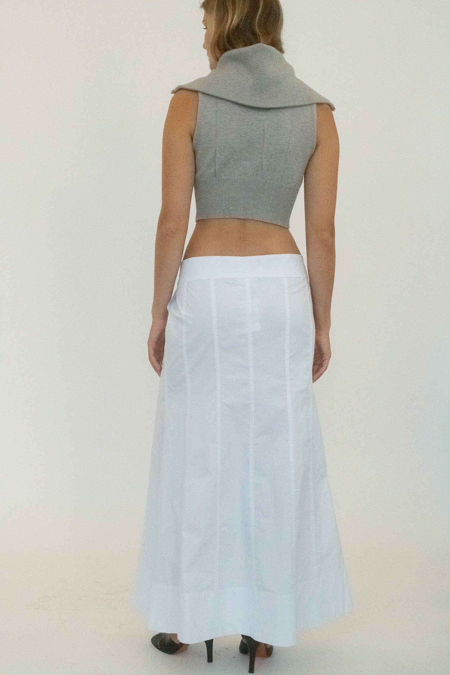 The paneled construction carves shape into the drape, while two-pocket styling adds a utilitarian nod without breaking the silhouette. 