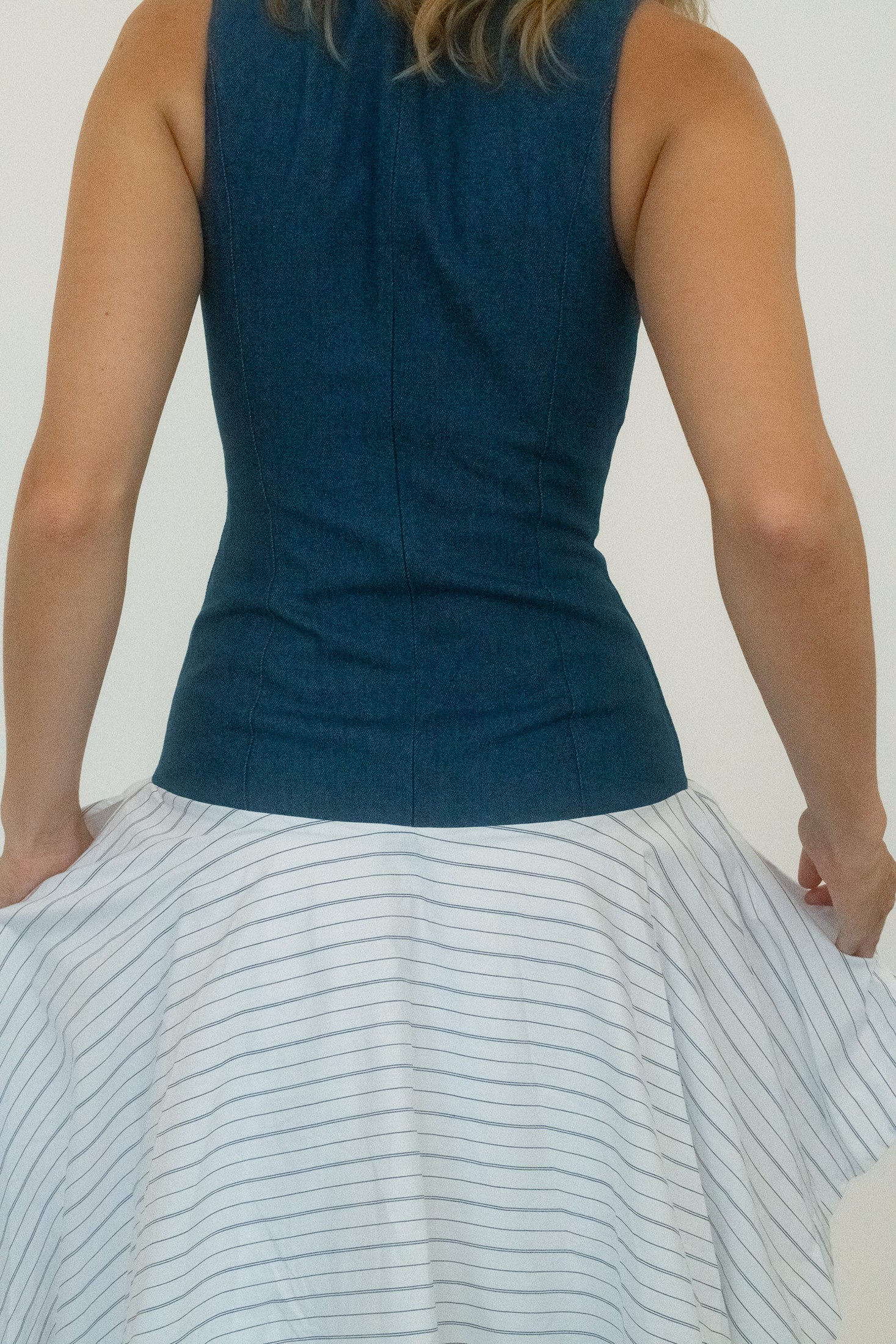 From there, it breaks away into a cotton poplin skirt, cut asymmetrically so the hem falls at unexpected angles.