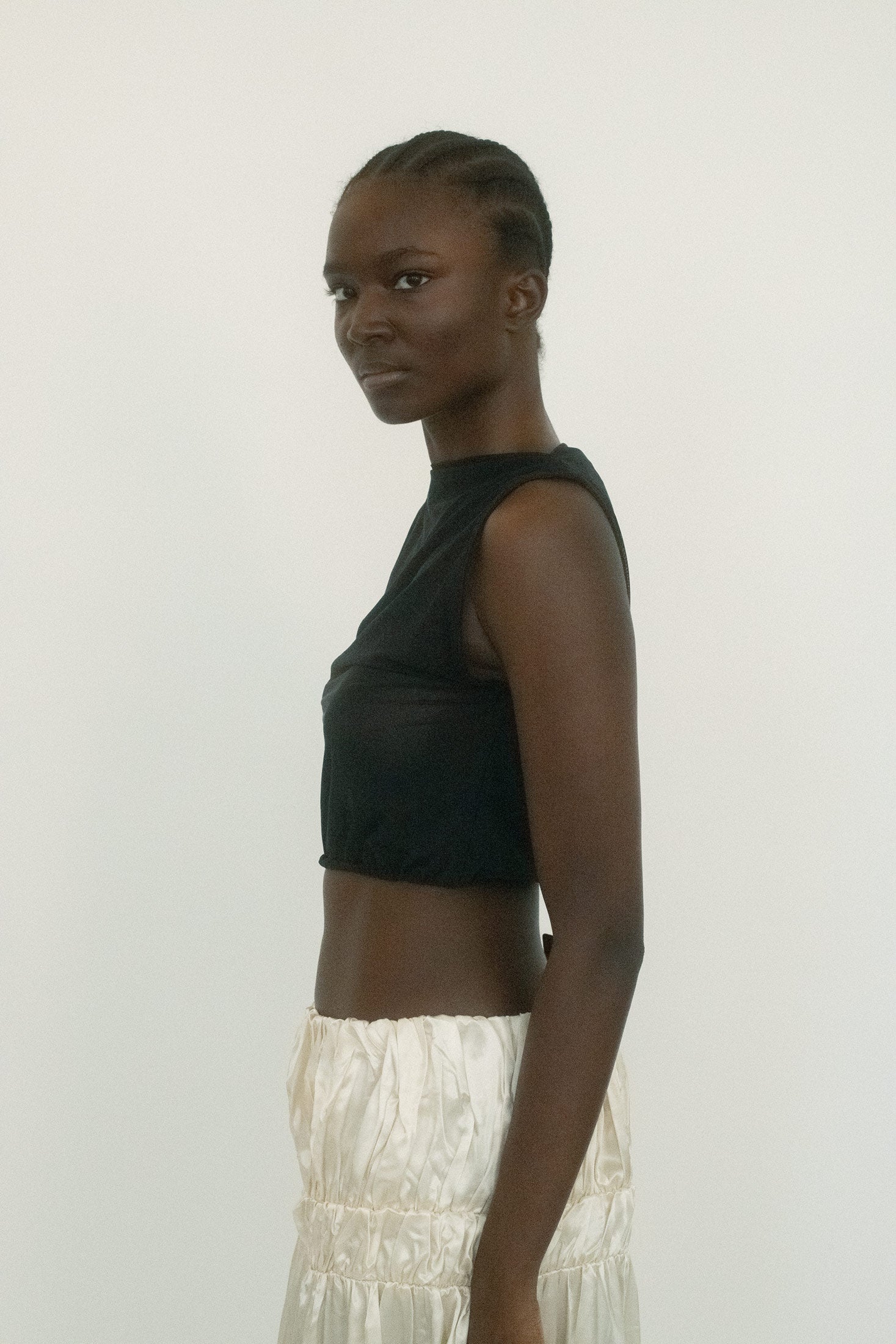 The drama comes from the asymmetrical ruffled sleeve, a detail that turns sculptural: part shadow, part flourish. 