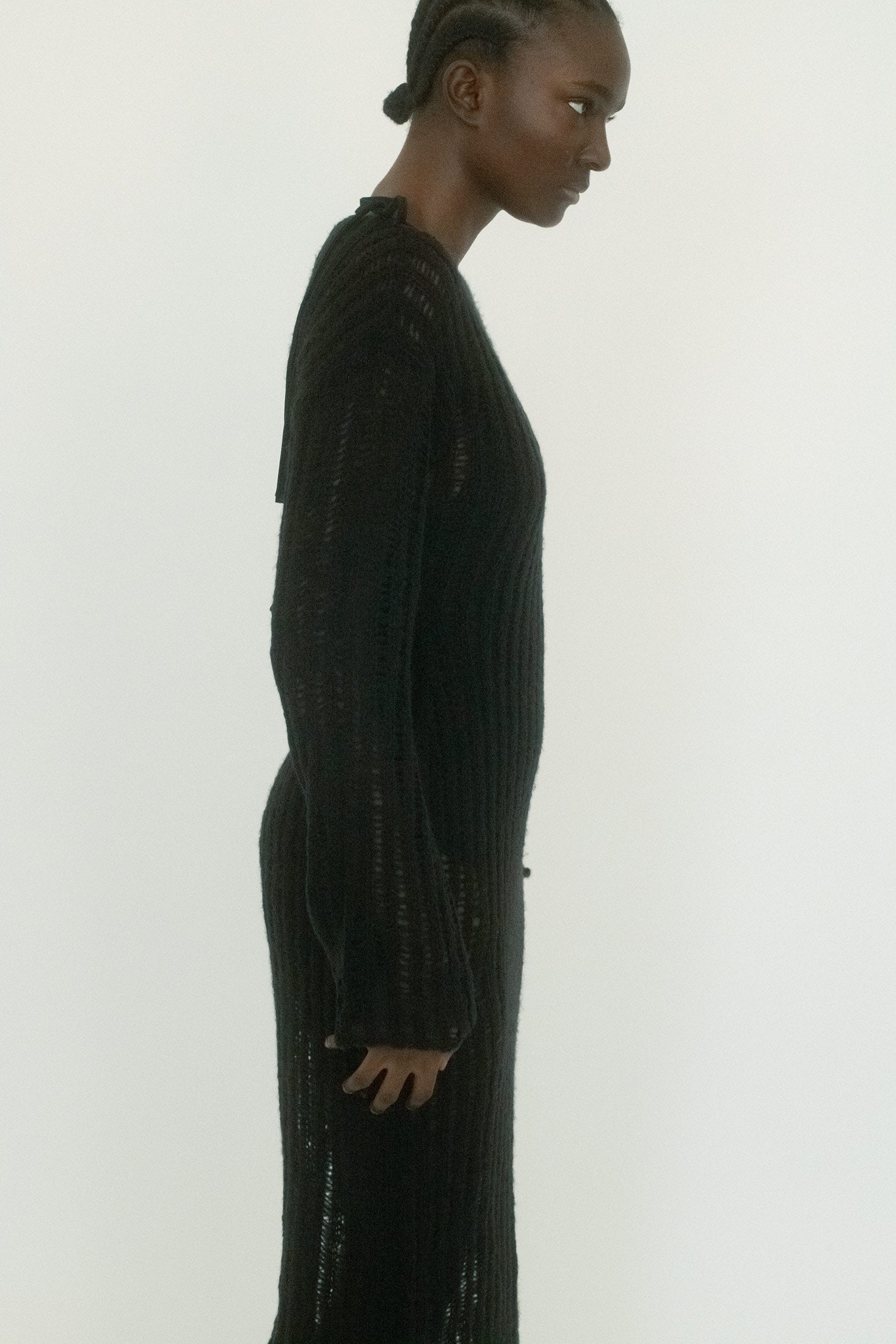 The long sleeves and high neckline temper the exposure, adding a note of restraint to the otherwise suggestive transparency.