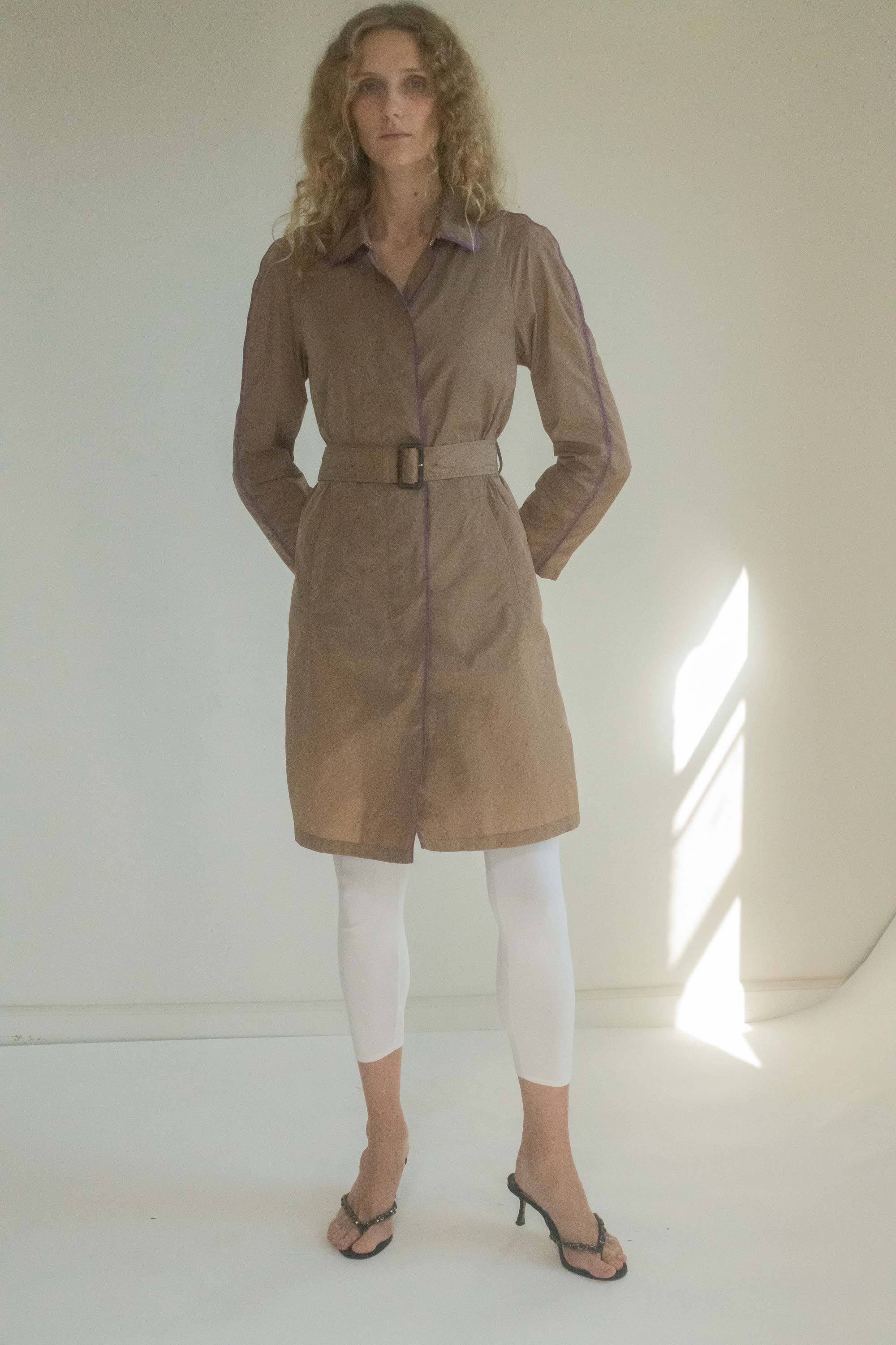 Designed with a pointed collar and a flattering knee-length cut, this fitted trench coat embodies city glamour. 