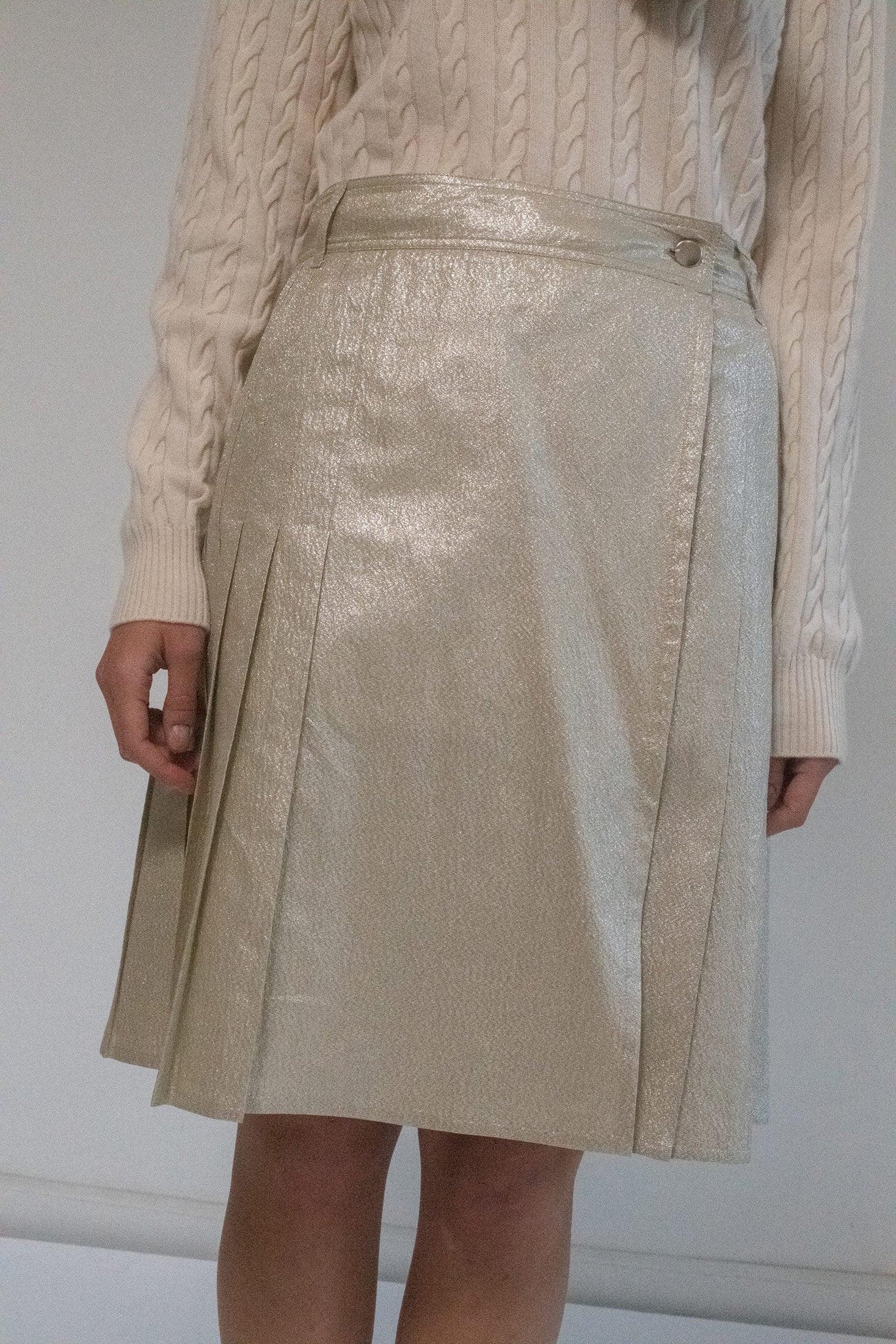 Enter the realm of sophisticated allure with the Prada Metallic Pleated Skirt, a knee-length masterpiece that redefines chic elegance. 