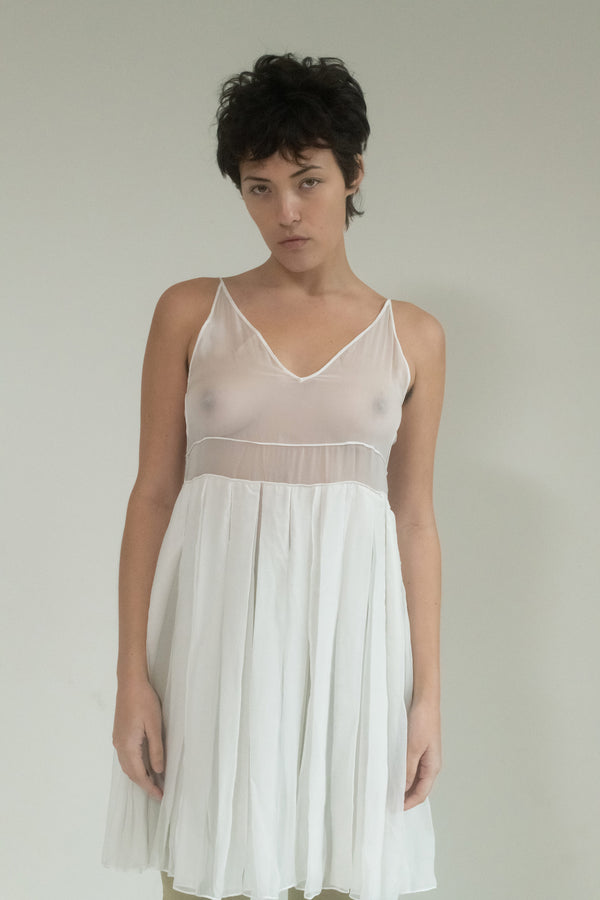 A pleated skirt slip dress that dances like a whispered intrigue through the night. 