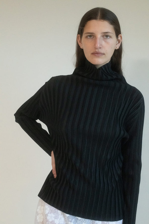 The "Pleats Please" classic black turtleneck – more than just fabric, more than just a top. The classic black turtleneck is no longer just a staple; it’s a statement.