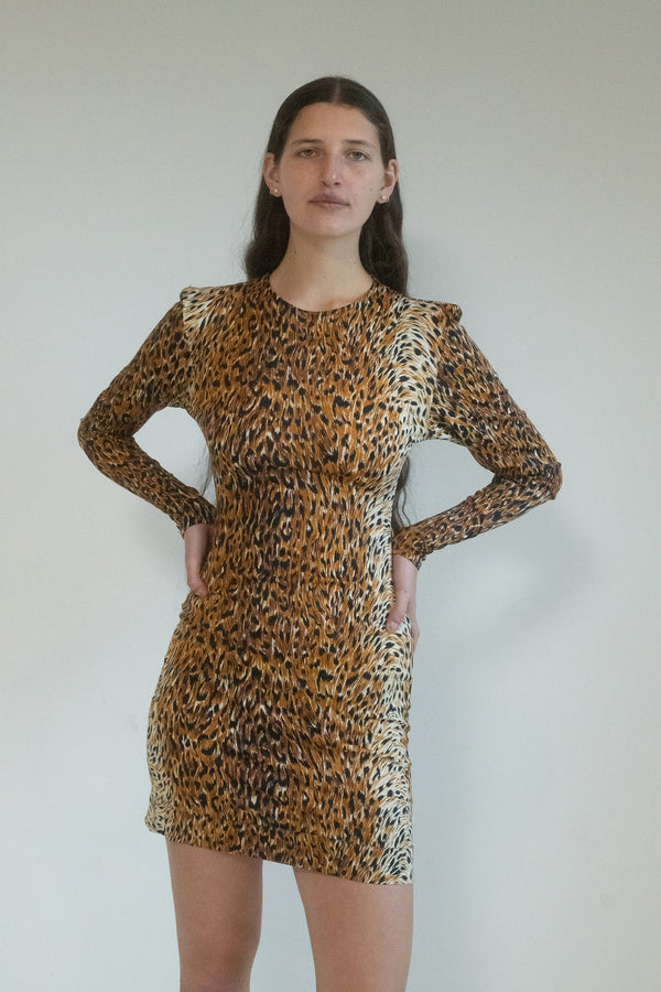 The night air is thick with anticipation as you slip into the Norma Kamali Cheetah Print Mini Dress.